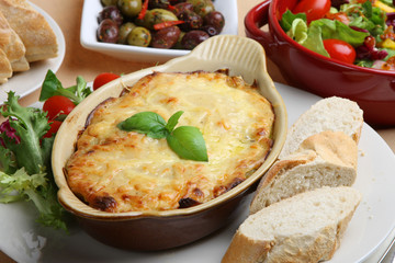 Canvas Print - Lasagna with Italian salad and a crusty baguette