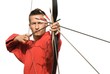 Young archer concentrating and aiming, frontal view