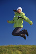 © Jacek Chabraszewski - Young girl wearing winter jacket jumping against blue sky