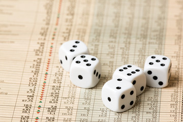 Dice and stock market charts in the newspaper