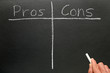 © Sharpshot - Writing the pros and cons on a blackboard.