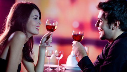 Wall Mural - young couple celebrating with red wine at restaurant