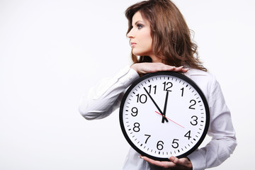 Young attractive business woman in white shirt holding clock.