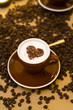 cup of cappuccino with heart shape on froth, coffeebeans