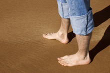 Male Legs On A Sand