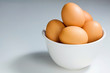 Fresh Brown Eggs In White Bowl on Blue-Grey Background
