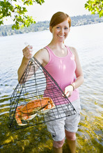 Woman Holding Crab In Trap