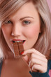 Young woman bites chocolate