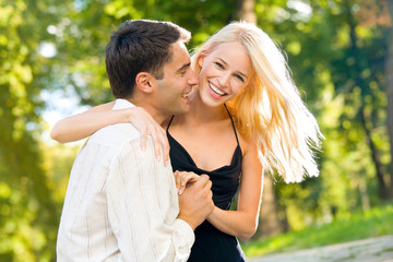 young happy smiling couple walking outdoors together