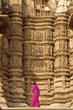 Tourist looking at erotic temple carvings at Khajuraho, India