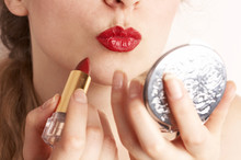 Woman Applying Red Lipstick Looking In The Mirror