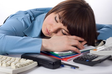 beautiful young business woman lies on desktop and sleeps