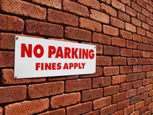 No Parking Sign On A Red Brick Wall