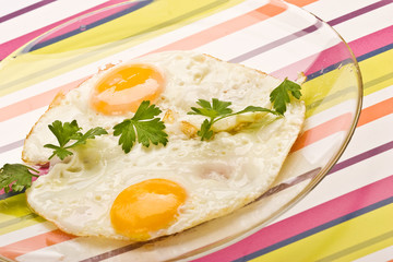 Wall Mural - food series: fried eggs with parsley on the glassy plate