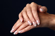 Beautiful woman hand with french manicure, isolated on black bac