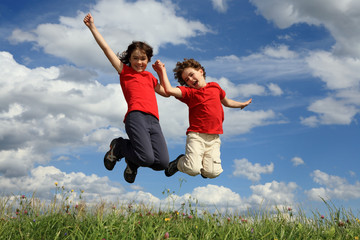 Wall Mural - Kids jumping, running against blue sky