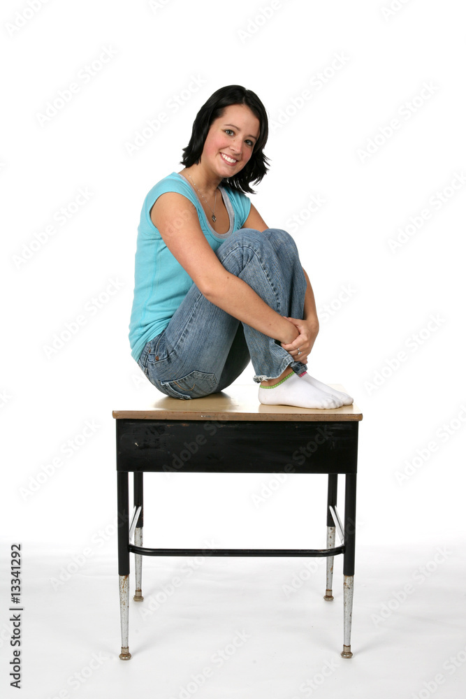 pretty teenage girl sitting on the top of a school desk Stock Photo ...