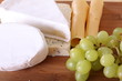 set of cheese and green grape on wood tray