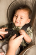 happy ethnic Asian baby boy child put in carseat