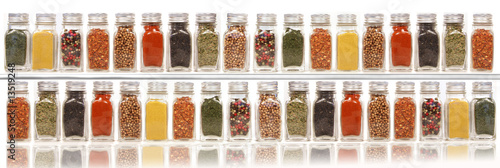 Fototapeta na wymiar Assorted spices on two layer shelves against white