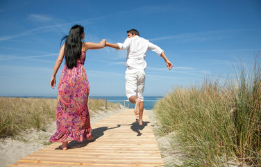 love couple running with holding hands to the beach