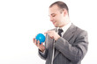 © Andreea Ardelean - Successful business man with globe over a white background