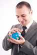 © Andreea Ardelean - Successful business man with globe over a white background