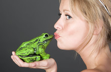 Shot Of A Pretty Blonde Girl Kissing A Frog