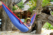 boy in a hat and sunglasses in a blue hammock