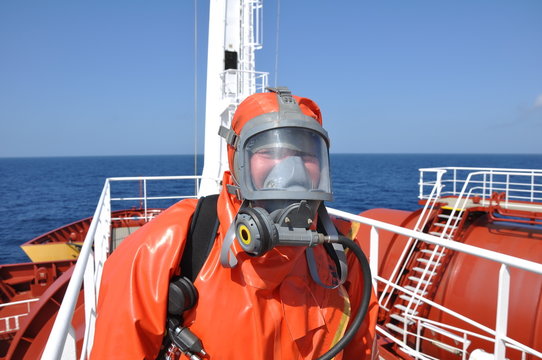 Fototapete - man in chemical suit on deck of chemical tanker