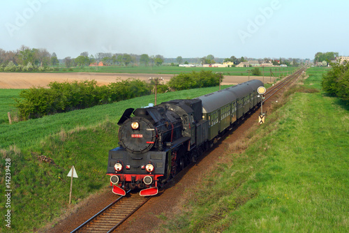 Naklejka ścienna Steam retro train passing the village