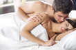 © vgstudio - Couple kissing and hugging on the bed in bedroom