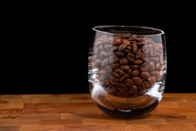 Coffea Beans In Glass On Wooden Table, Black Background