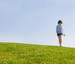 © FOTOCROMO - Young woman walking on the green hill in a beautiful sunny day
