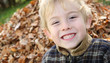 © soupstock - Smiling boy in front of a pile of leaves