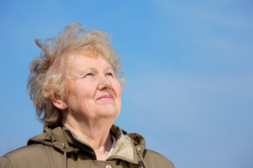 Wall Mural - Smiling aged woman look in sky