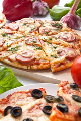 different sliced pizzas with ingredients