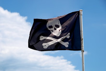 Jolly Roger Flag Against Blue Sky