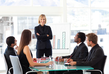 Wall Mural - Businesswoman smiling with folded arms in a meeting