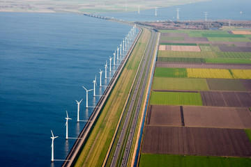 Dutch farmland with windmills along the dike