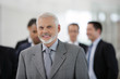© auremar - Homme d'affaires souriant en costume devant un groupe