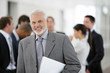© auremar - Homme actif souriant avec un ordinateur portable sous le bras