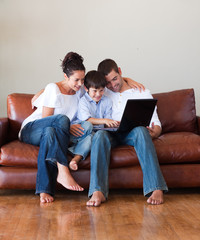 Wall Mural - Parents and son playing with a laptop