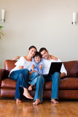 Wall Mural - Family using a laptop with thumbs up and copy-space