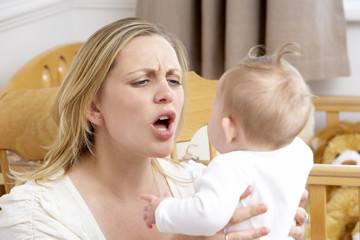 Stressed Mother Holding Baby In Nursery