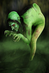 Wall Mural - Green looking witch like creature in swamp