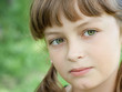 Fullface portrait of serious little girl with green eyes
