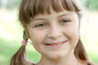 Fullface portrait of smiling little girl with green eyes and blo