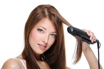 girl doing hairstyle with flat iron