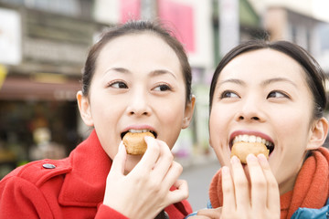 Canvas Print - 観光地でまんじゅうを食べる女性2人